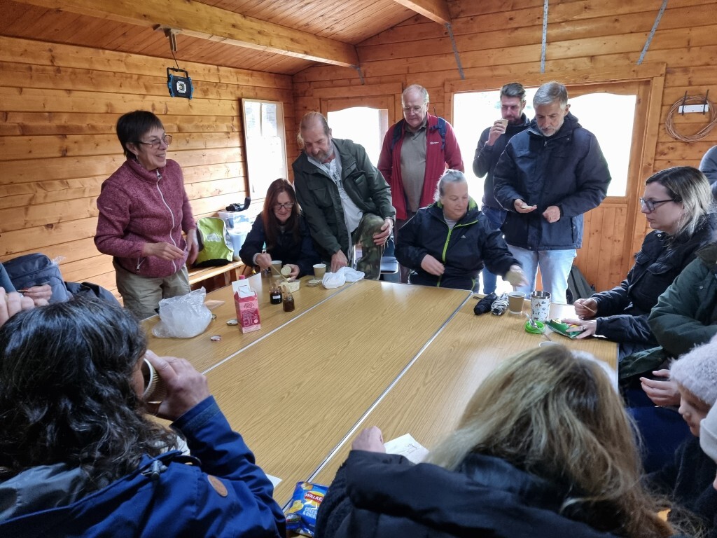 Anna in the cabin showing the attendees products made from foraged ingredients.